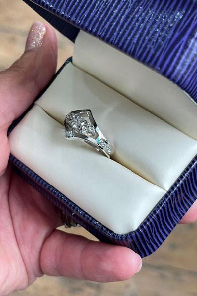 Silver diamond ring in purple ring box